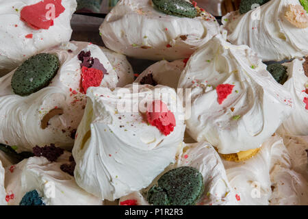 Una selezione di gustosi ingrasso e zuccherino di meringhe sul visualizzatore in corrispondenza di una torta e di stallo dolciario sul mercato di Borough di Londra. dolci e torta delicata Foto Stock