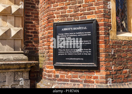 Firmare all'entrata di Abbot's Hospital, un punto di riferimento almshouse edificio storico in High Street, Guildford, capoluogo di contea di Surrey, Inghilterra del sud-est Foto Stock