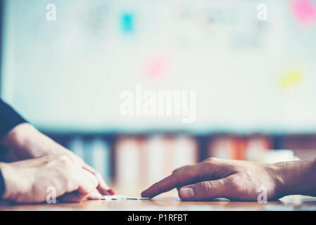 Le mani cercando di collegare il giovane pezzo di puzzle con sfondo, una parte della intera. il simbolo di associazione e connessione. strategia di business. Foto Stock