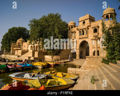 Barche colorate di attracco lungo la riva del lago Gadsisar; Jaisalmer, Rajasthan, India Foto Stock