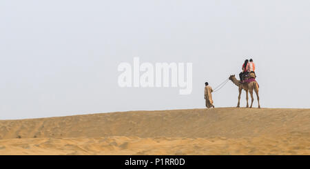 Un giovane su un cammello safari sulle dune Lakhmana; Damodara, Rajasthan, India Foto Stock