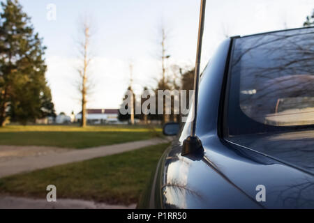 In primo piano di una antenna auto da dietro in park |tramonto Foto Stock