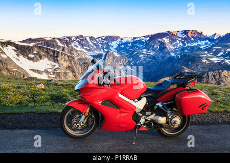 Vista da la Beartooth Highway della Beartooth montagne e una moto parcheggiata sul ciglio della strada; Cody, Wyoming, Stati Uniti d'America Foto Stock