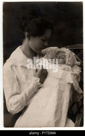 Germania - 25 Aprile 1918: Vintage mostra fotografica di Donna con bambino (il neonato in fasce. Retrò in bianco e nero studio fotografico. Foto Stock
