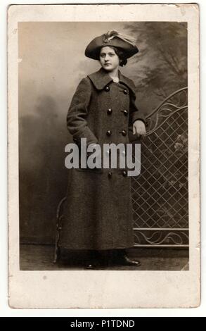 Praga, la Repubblica cecoslovacca - circa 1940s: Vintage mostra fotografica di donna indossa ladies hat e lungo il segnale di PEA coat/lunga reefer giacca. Retrò fotografia in bianco e nero. Foto Stock