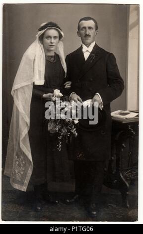 PRAHA (Praga), la Repubblica cecoslovacca - circa 1921: Vintage mostra fotografica di sposi novelli. La sposa indossa lungo velo bianco. Retrò in bianco e nero studio fotografico di coppia sposata. Foto Stock