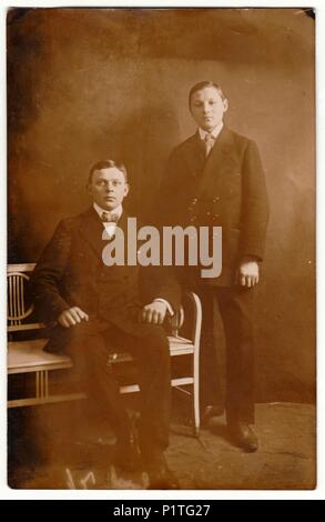 Amburgo, Germania - circa 1910s: Vintage mostra fotografica di giovani ragazzi (fratelli) pongono in uno studio fotografico. Retrò fotografia in bianco e nero con effetto seppia. Foto Stock