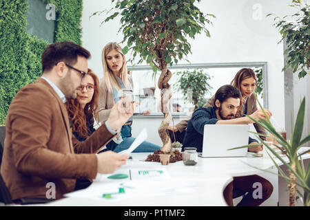 Team di biologi università tenendo esperimento su germogliare e controllare l'analisi del campione di pianta. Foto Stock