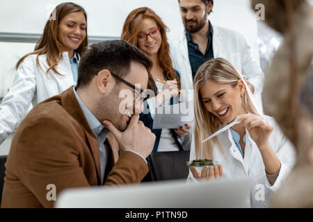 Università collega biologi tenendo esperimento su germogliare e controllare l'analisi del campione di pianta. Foto Stock