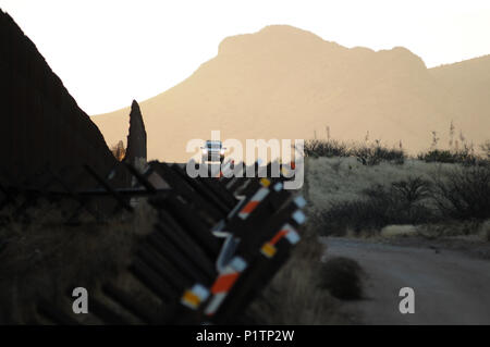 Un U.S. Pattuglia di Confine unità agente su una strada sterrata lungo gli Stati Uniti/Messico frontiera muro vicino al San Pedro River, Cochise County, Hereford, Arizona, Stati Uniti. Foto Stock