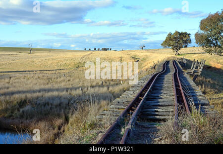 Vecchio abbandonato crooked rusty binari ferroviari sullo storico ponte sopra il fiume Boorowa attraverso rural central west NSW, Australia Foto Stock