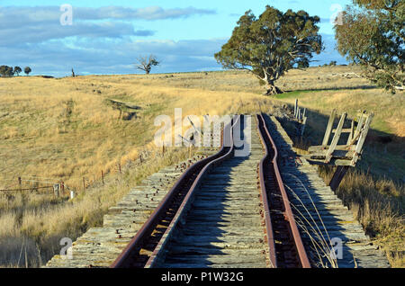 Vecchio abbandonato crooked rusty binari ferroviari sullo storico ponte sopra il fiume Boorowa attraverso rural central west NSW, Australia Foto Stock