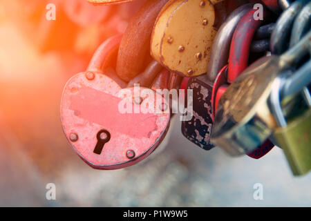 Close-up del castello di rosa e di altri castelli in forma di cuori sul vecchio ponte della città, la tradizione di amanti che il giorno del matrimonio Foto Stock