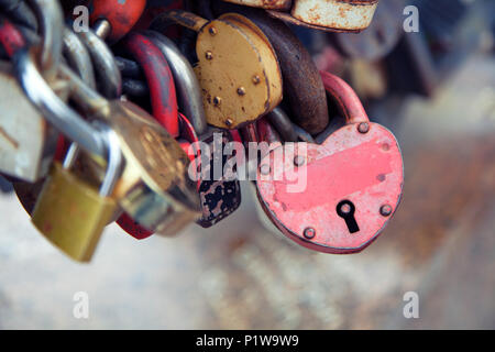 Close-up del castello di rosa e di altri castelli in forma di cuori sul vecchio ponte della città, la tradizione di amanti che il giorno del matrimonio Foto Stock