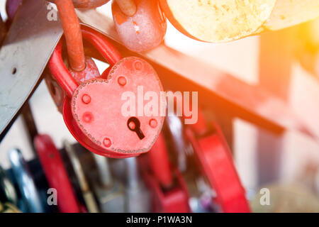 Close-up del castello di rosa e di altri castelli in forma di cuori sul vecchio ponte della città, la tradizione di amanti che il giorno del matrimonio Foto Stock