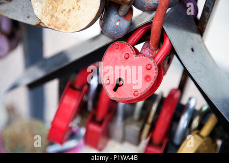 Close-up del castello di rosa e di altri castelli in forma di cuori sul vecchio ponte della città, la tradizione di amanti che il giorno del matrimonio Foto Stock