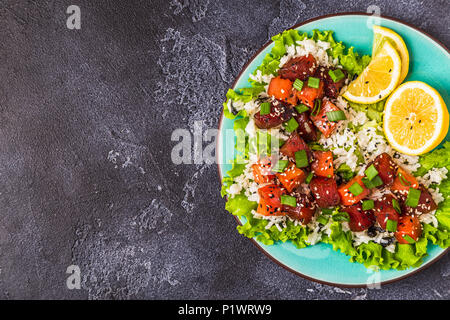 Invio di un poke, tradizionale Hawaiiano pesce crudo insalata, vista dall'alto. Foto Stock