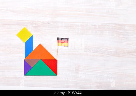 Da sopra il colpo di bright tangram mattoni composta in forma di casa con la bandiera tedesca sulla parte superiore. Foto Stock
