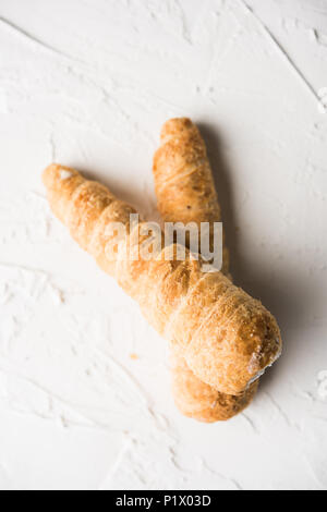 Puff rotoli di crema o pasta servita su moody sfondo. il fuoco selettivo Foto Stock