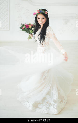 Bella giovane donna fidanzata in abito bianco. Sposa in movimento Foto Stock