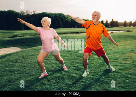 Coppia senior a praticare lo yoga insieme all'aperto Foto Stock