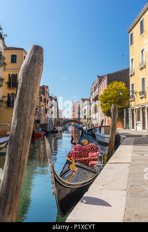 Gondola parcheggiata in attesa per i turisti a canale laterale a Venezia, Italia Foto Stock