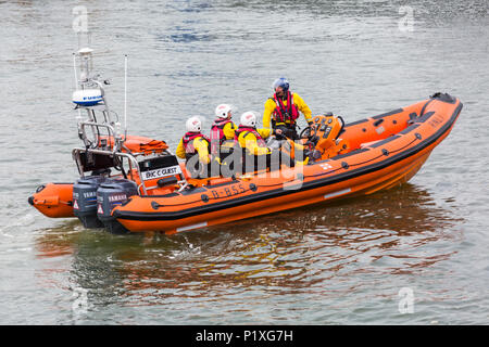 RNLI, Royal National scialuppa di salvataggio Istituzione, crew in gommone a Poole Harbour, Poole, Dorset, England Regno Unito nel mese di giugno Foto Stock
