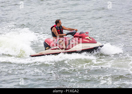 Man riding Jetski a Poole Harbour, Poole, Dorset, Inghilterra UK nel mese di giugno - jetski jet ski jetski jet ski jet ski jetski jet ski. Foto Stock