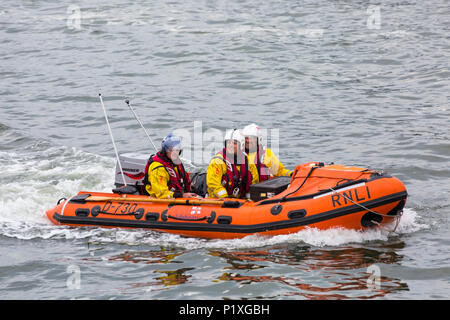 RNLI, Royal National scialuppa di salvataggio Istituzione, crew in gommone a Poole Harbour, Poole, Dorset, England Regno Unito nel mese di giugno Foto Stock