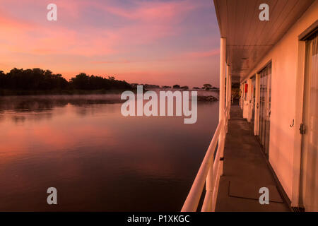Regione Pantanal, Mato Grosso, Brasile, Sud America. Sunrise colorate sul fiume Cuiaba, visto dalla passerella su un flotel (hotel galleggiante). Foto Stock