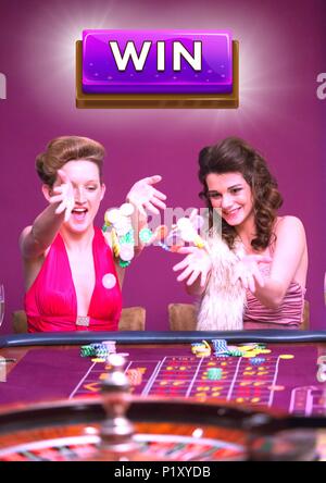 Pulsante di vincere con due donne a giocare nel Casino Foto Stock