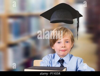 Ragazzo scuola nella libreria di istruzione con graduazione hat Foto Stock