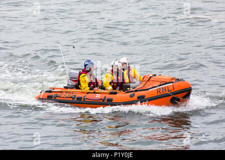 RNLI, Royal National scialuppa di salvataggio Istituzione, crew in gommone a Poole Harbour, Poole, Dorset, England Regno Unito nel mese di giugno Foto Stock