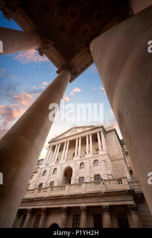 La Banca di Inghilterra Heaquarters su Threadneedle Street nella città di Londra, Inghilterra, visto attraverso le colonne del Royal Exchange al tramonto Foto Stock