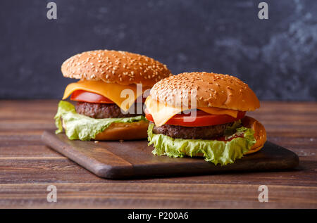 Foto di due hamburger su una tavola di legno Foto Stock