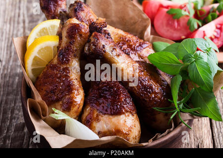 Pollo arrosto cosce di pollo disossate in vaso di ceramica e verdure fresche sulla tavola in legno rustico, cibo preferito Foto Stock