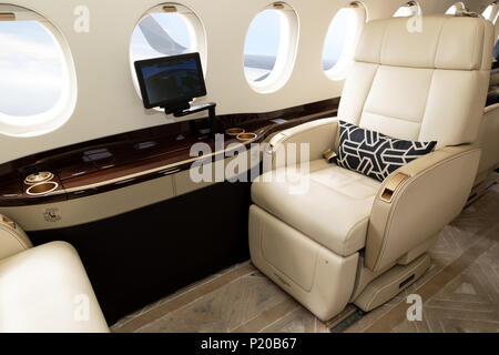 Cabina Comfortible sedia in un moderno business jet durante il volo. Foto Stock