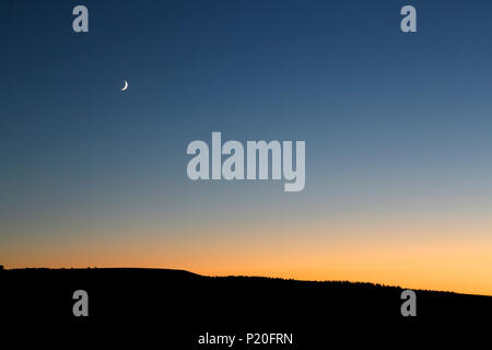 Il Massiccio Centrale. Cantal. Trizac Plateau. Twilight sulla scheda d'estate. Luna crescente. Foto Stock