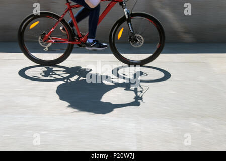 Sfocata ciclista silhouette e ombra su una bicicletta Foto Stock
