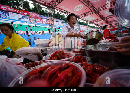 (180613) -- XUYI, 13 giugno 2018 (Xinhua) -- venditori vendono astaci durante un grande banchetto di gamberi in Xuyi, est cinese della provincia di Jiangsu, 13 giugno 2018. Più di 50.000 residenti e turisti hanno preso parte alla festa qui mercoledì. Gamberi di fiume-industrie correlate in Cina ha visto la forte crescita dello scorso anno come uscita totale di schizzata da 83,15 percento a 268.5 miliardi di yuan (42 miliardi di dollari) nel 2017, detto un rapporto rilasciato martedì. Un totale di 1,13 milioni di tonnellate di gamberi di fiume sono state sollevate lo scorso anno, con le province di Hubei, Anhui, Hunan, Jiangsu Jiangxi e come i grandi produttori. (Xinhua/Li Xian Foto Stock