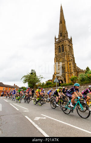 Giorno due del Grand partono da Rushden, Northamptonshire dell'OVO energia donna ciclo Tour 2018. I ciclisti gara passato la mitica chiesa di Santa Maria in High Street in Rushden, Northamptonshire. Credito: GLC Pix/Alamy Live News Rushden, Regno Unito. 14 giugno 2018. Foto Stock