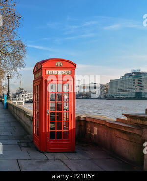 Classic British telefono rosso casella al Tamigi nel centro di Londra. Foto Stock