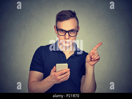 Uomo con lo smartphone non mostrando alcun, attenzione con il dito il gesto a mano. Bloccare pericolosi contenuti per adulti. Il controllo parentale nozione Foto Stock