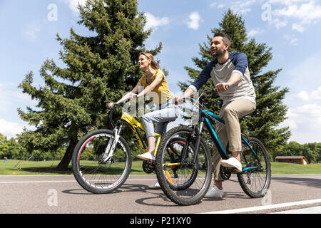 I giovani casual giovane a cavallo di biciclette nel parco di giorno Foto Stock