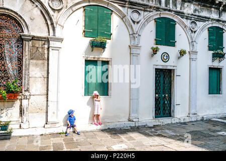 Ragazzo e ragazza esplorate le tranquille piazze a Venezia su una famiglia amichevole vacanza in Italia. Foto Stock