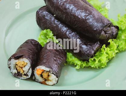 La cucina giapponese, Vagetarian tradizionale di riso giapponese maki sushi Roll roba con tofu e carote avvolte in Nori alghe servita sulla quercia verde. Foto Stock