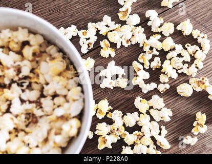 Direttamente al di sopra di close-up di ciotola riempita con popcorn su tavola in legno rustico Foto Stock