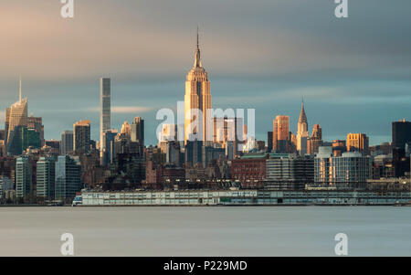 Panoramica Esposizione lunga dell'Empire State Building e la skyline di Manhattan al tramonto dalla attraverso il fiume Hudson in New Jersey, New York, Stati Uniti d'America Foto Stock