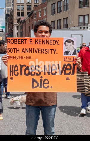 Un giovane uomo tenendo un cartello per l anniversario di Robert F. Kennedy è morte proclamando che gli eroi non muoiono mai. In Union Square Park a New York City Foto Stock