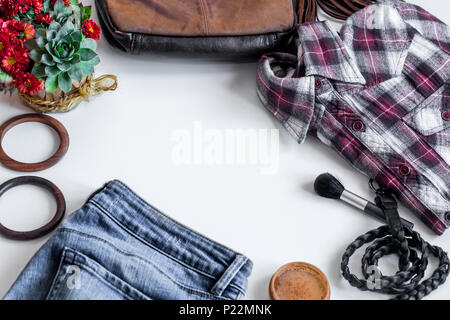 Un set di abbigliamento femminile,accessori, jeans, t-shirt, cinghia,cosmetici ,bracciali fiori su sfondo bianco Foto Stock